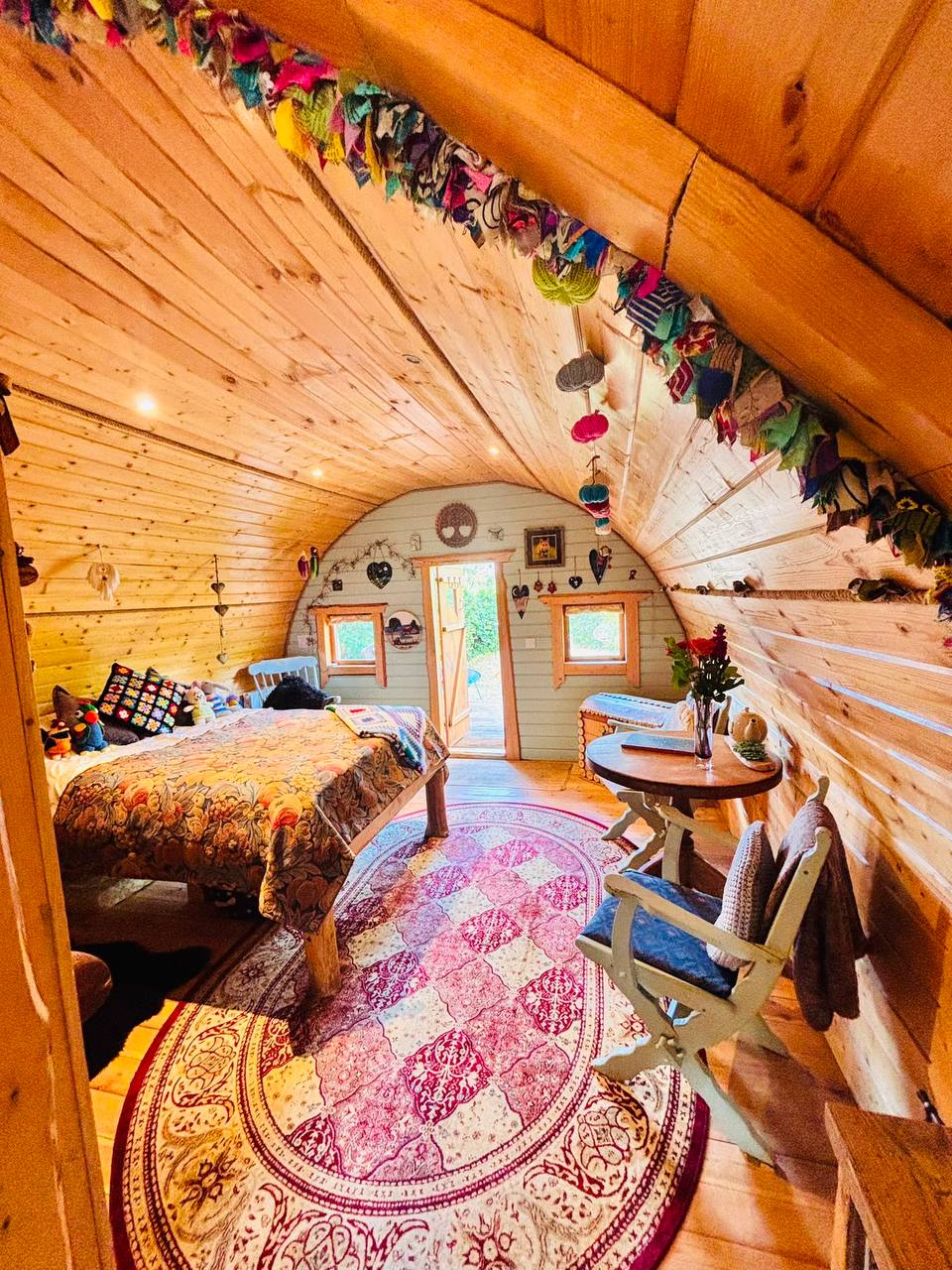 The arched interior of the hobbit house looking from the bed to the tea table