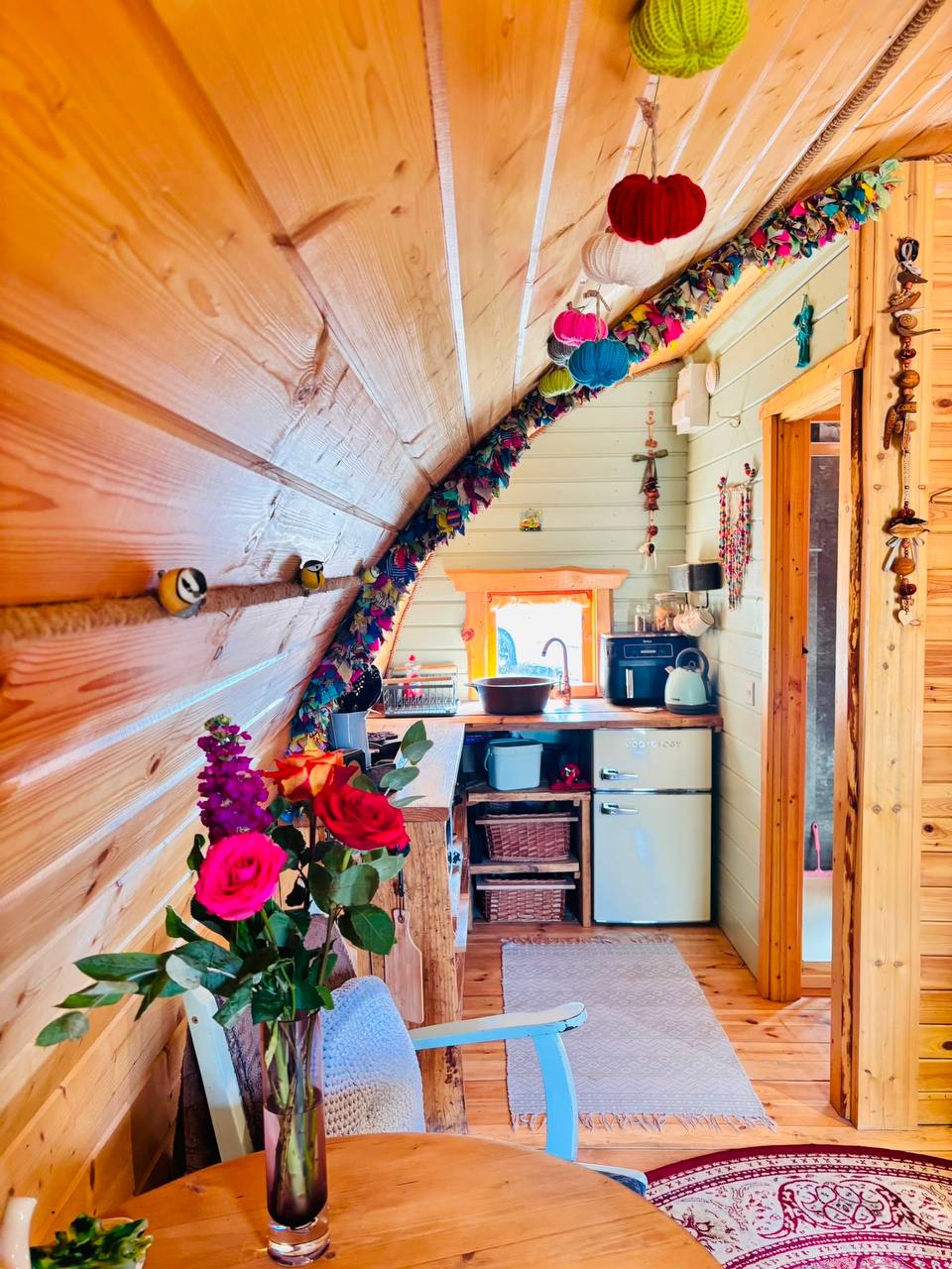 Inside the hobbit house — the kitchen corner with retro fridge, kettle and hanging knitted decorations