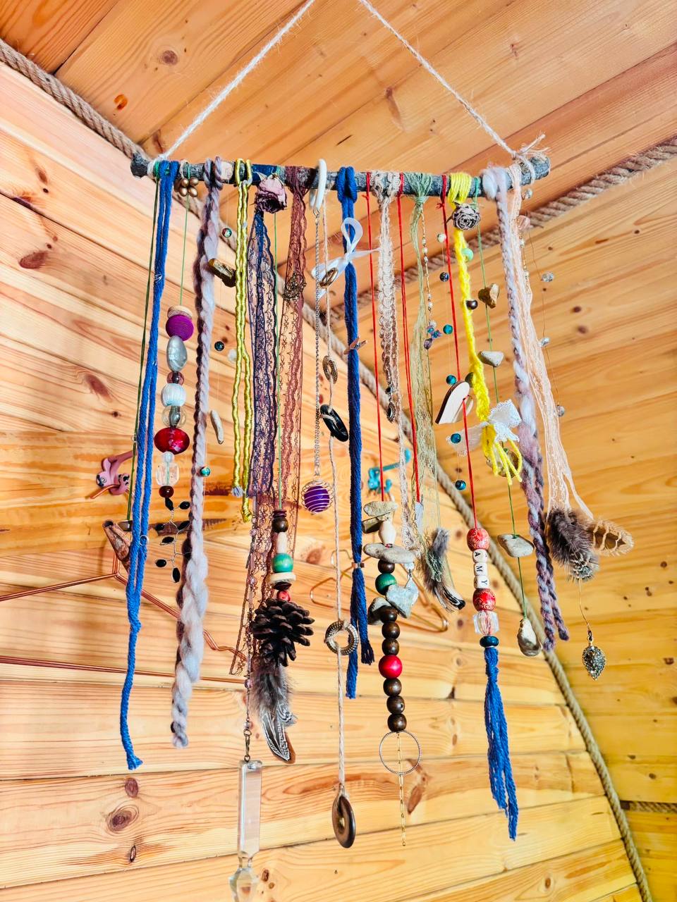 Handmade beaded and woollen mobile hanging from the timber ceiling of the hobbit house